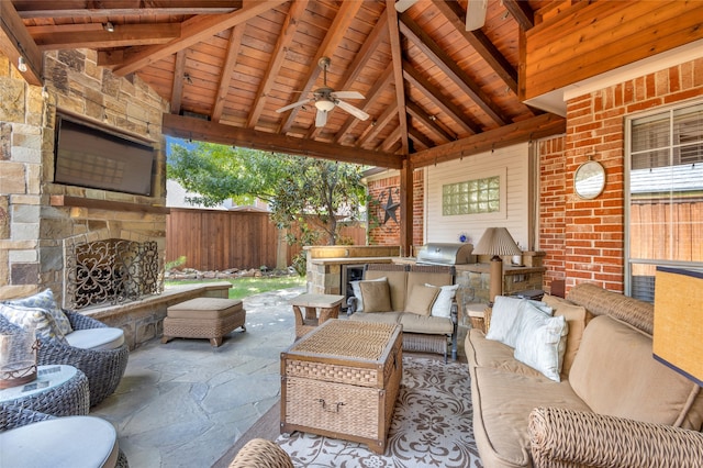 view of patio / terrace with an outdoor kitchen, a gazebo, ceiling fan, an outdoor stone fireplace, and a grill