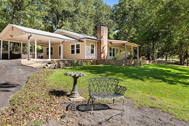 rear view of house with a yard and a carport