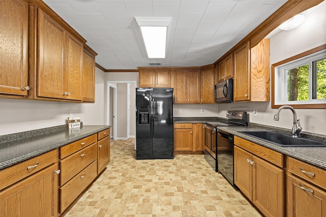 kitchen with ornamental molding, sink, and black appliances