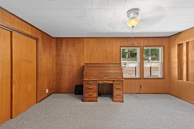 carpeted office featuring ornamental molding and wooden walls