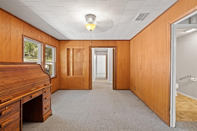 carpeted home office featuring ornamental molding and wooden walls