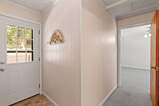 doorway featuring crown molding, light colored carpet, and wooden walls