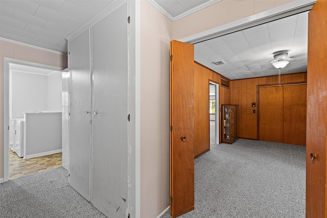 corridor with crown molding, light colored carpet, and wooden walls