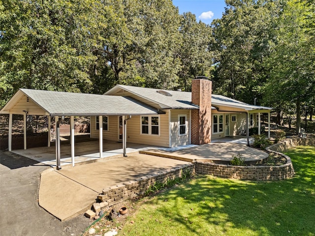 rear view of house with a yard and a patio