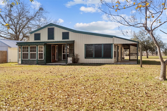 back of property with a yard and a patio