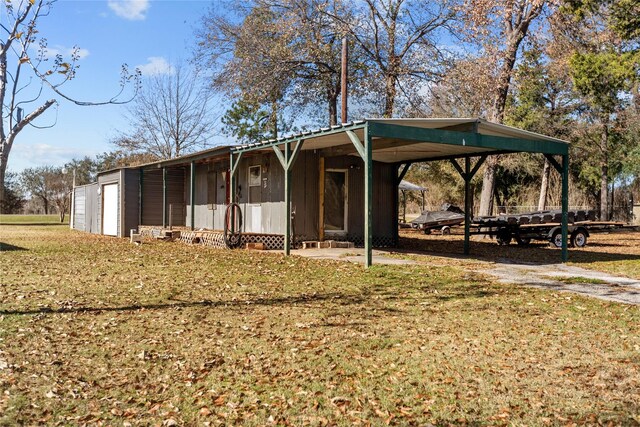 view of front of home with a carport, a front yard, and a garage