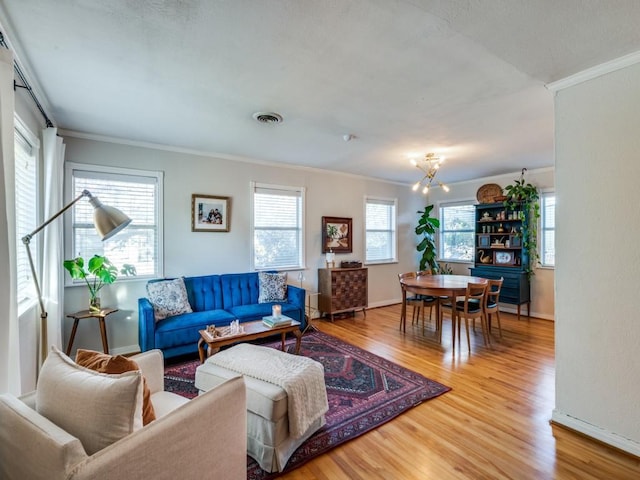 living room featuring a wealth of natural light, crown molding, an inviting chandelier, and hardwood / wood-style flooring