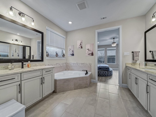 bathroom with tile patterned flooring, vanity, a relaxing tiled tub, and ceiling fan