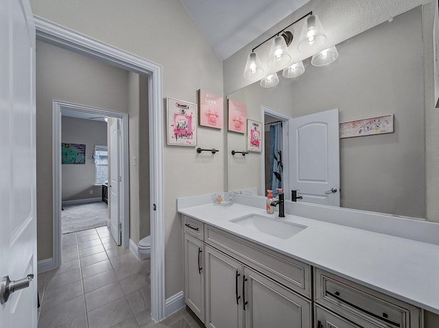 bathroom featuring tile patterned flooring, vanity, and toilet