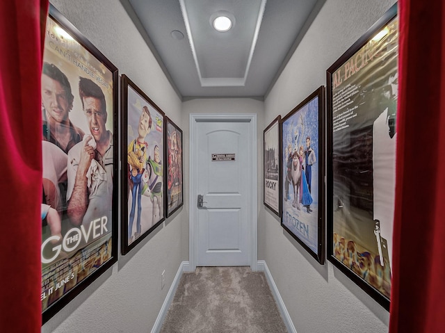 hall featuring carpet floors and a tray ceiling