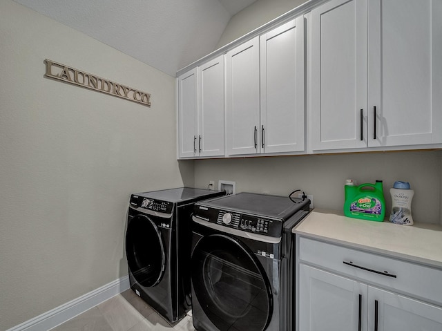 laundry room featuring washer and clothes dryer, light tile patterned flooring, and cabinets