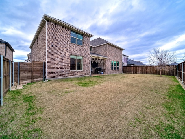 rear view of property with a yard and a patio area