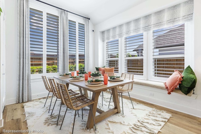 dining area with lofted ceiling and light wood-type flooring