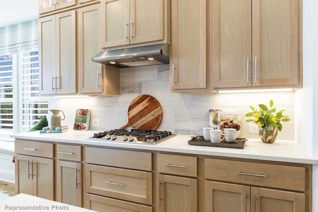 kitchen featuring stainless steel gas cooktop, backsplash, and light brown cabinetry