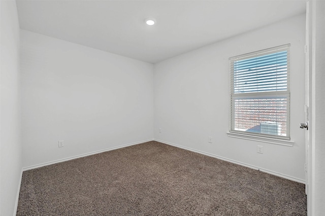 unfurnished room with dark carpet