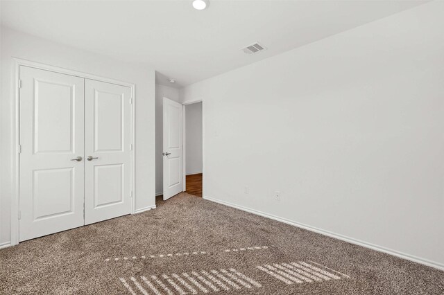 unfurnished bedroom with carpet flooring and a closet