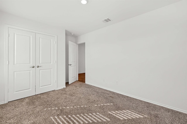 unfurnished bedroom with carpet floors and a closet