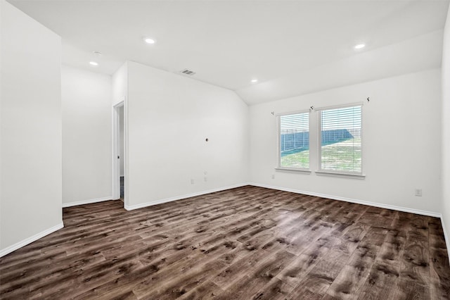 spare room with dark hardwood / wood-style flooring and vaulted ceiling