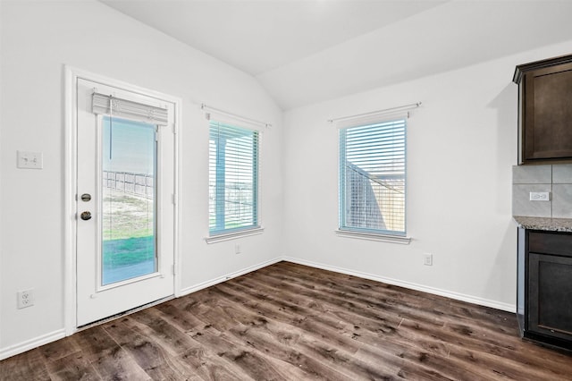 unfurnished dining area with plenty of natural light, dark wood-type flooring, and vaulted ceiling