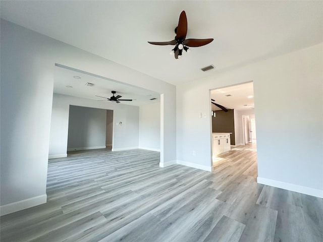 empty room with ceiling fan and light hardwood / wood-style flooring