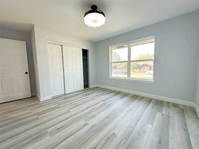 unfurnished bedroom featuring light hardwood / wood-style floors and a closet