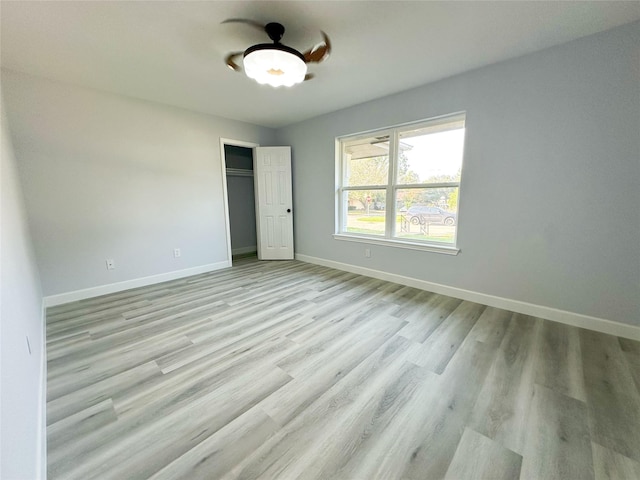 unfurnished bedroom featuring light wood-type flooring and a closet