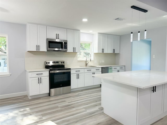 kitchen featuring stainless steel appliances, sink, and white cabinets