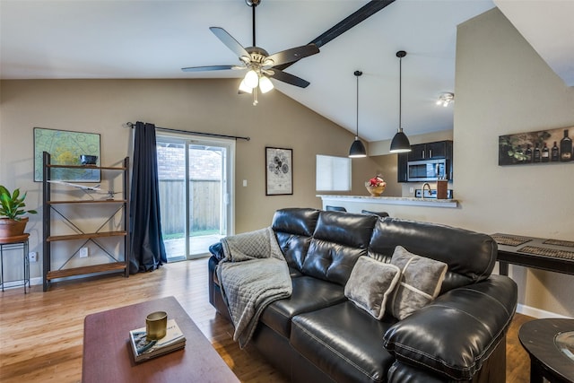 living room with wood-type flooring, vaulted ceiling, and ceiling fan