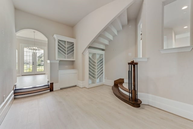 interior space featuring french doors, an inviting chandelier, and light hardwood / wood-style flooring