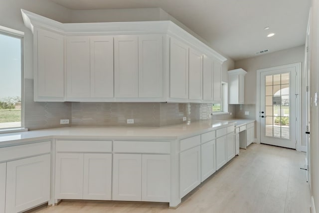 kitchen featuring tasteful backsplash and white cabinets