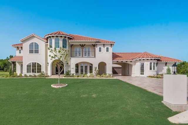 back of house featuring french doors, a yard, stucco siding, a balcony, and a tiled roof