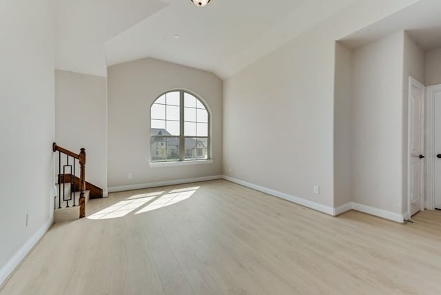 unfurnished living room featuring lofted ceiling and light wood-type flooring