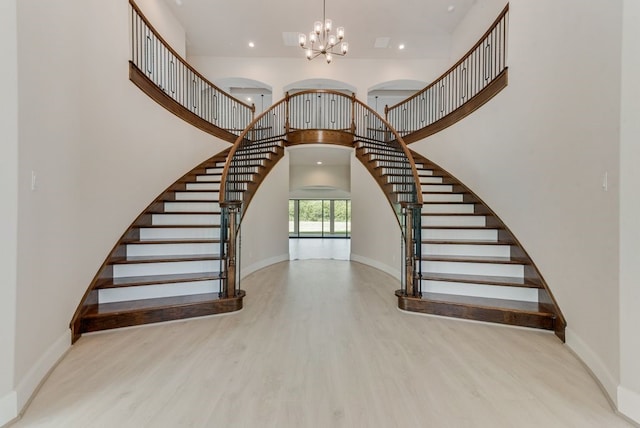 stairs featuring baseboards, a high ceiling, and wood finished floors