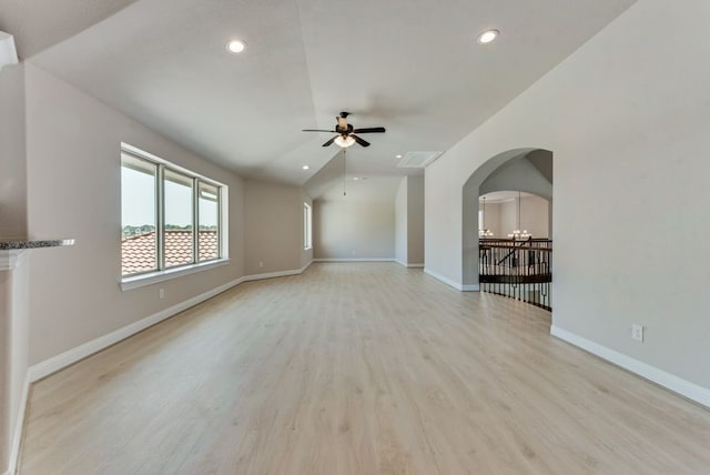 unfurnished living room featuring ceiling fan with notable chandelier, lofted ceiling, and light hardwood / wood-style floors