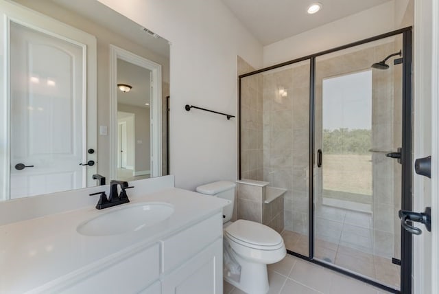 bathroom featuring a shower with door, vanity, tile patterned floors, and toilet