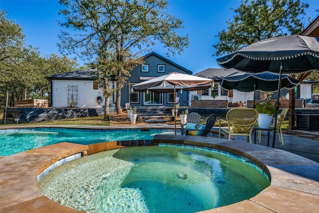 view of pool with a patio and an in ground hot tub