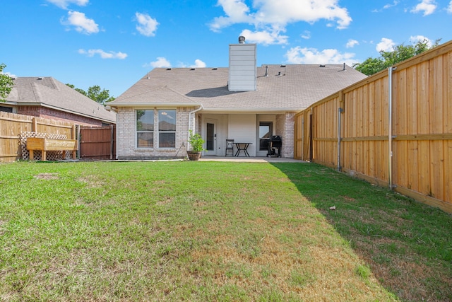 rear view of house with a lawn and a patio