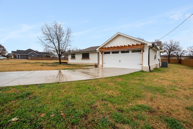 single story home featuring a garage, a front yard, and central air condition unit