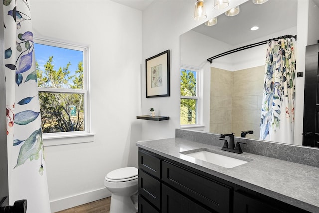 bathroom featuring vanity, hardwood / wood-style floors, curtained shower, and toilet