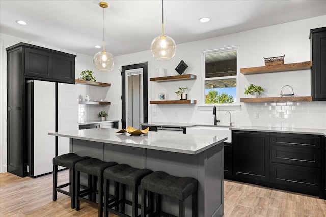 kitchen featuring a center island, white fridge, sink, and pendant lighting