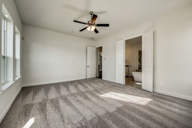 unfurnished bedroom with ensuite bath, light colored carpet, and ceiling fan