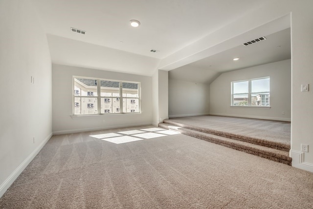 additional living space with lofted ceiling and light carpet