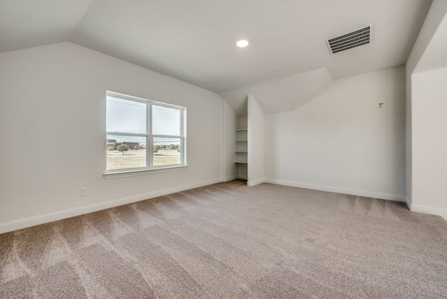 additional living space featuring lofted ceiling and carpet floors