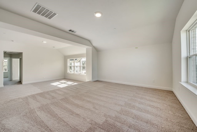 carpeted spare room featuring lofted ceiling