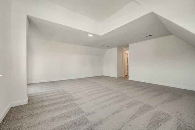 bonus room with light colored carpet and lofted ceiling