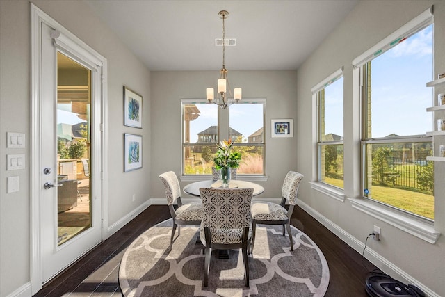 sunroom / solarium with a wealth of natural light and an inviting chandelier