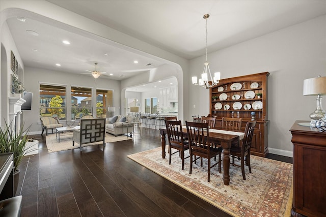 dining area with wood-type flooring and ceiling fan with notable chandelier