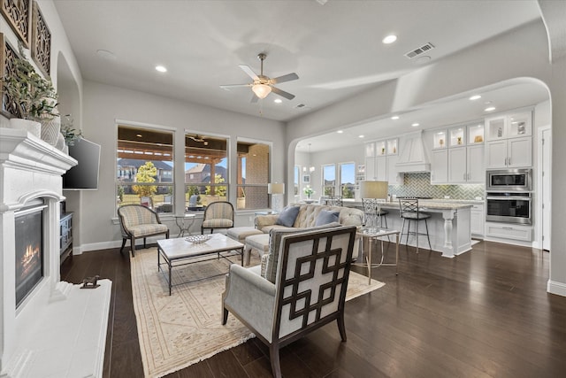 living room with ceiling fan and dark hardwood / wood-style floors