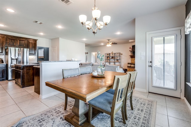 tiled dining area featuring ceiling fan with notable chandelier