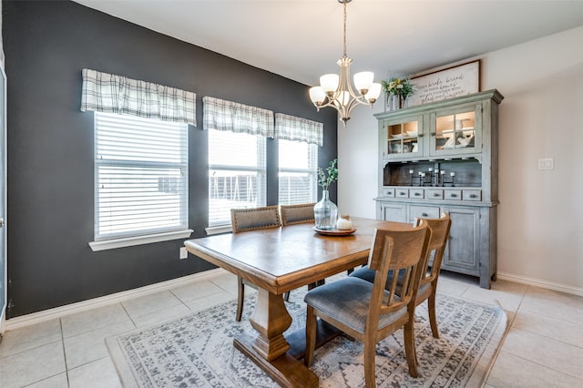 tiled dining room with an inviting chandelier